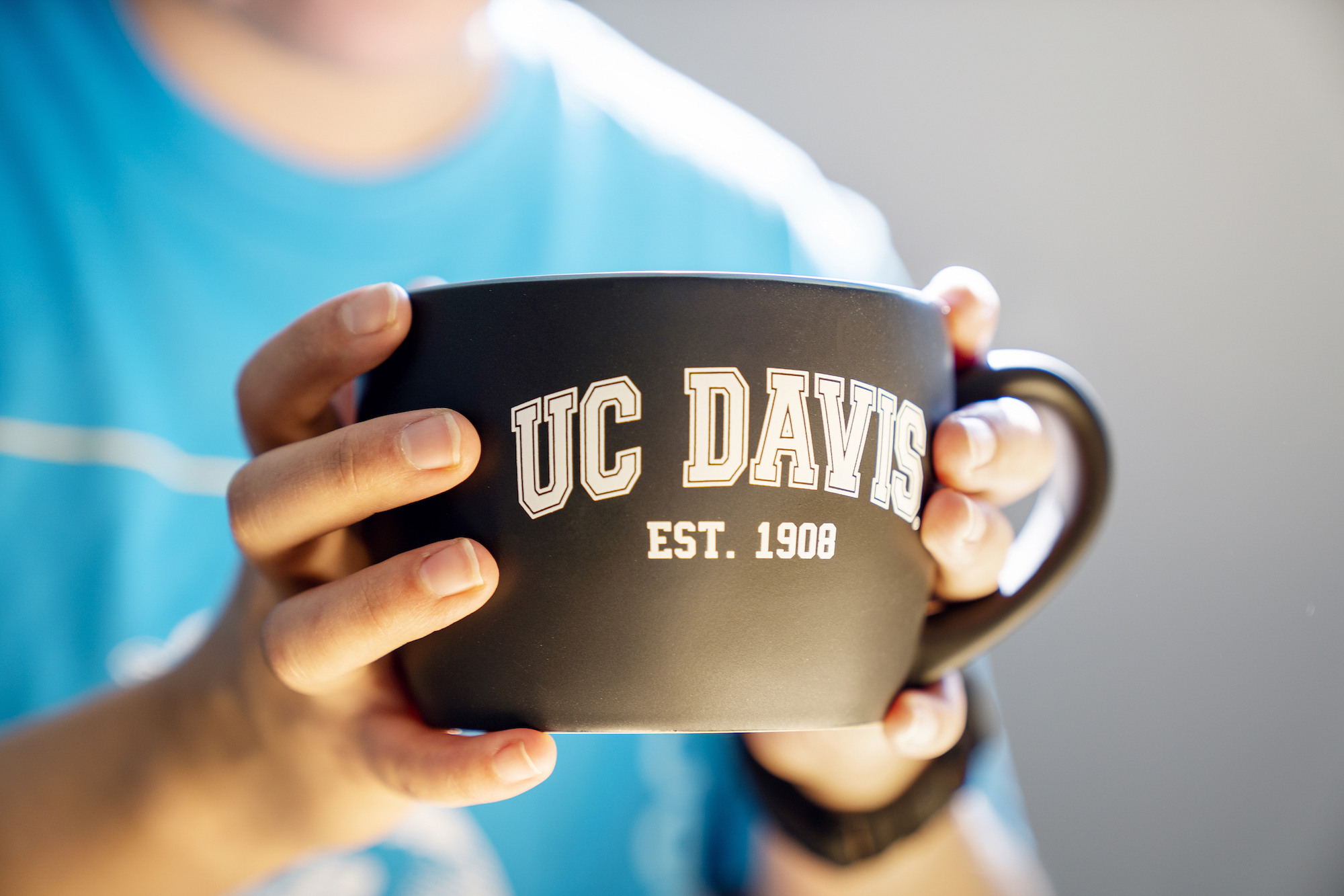 Hands holding UC Davis mug